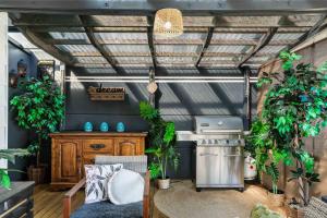 a kitchen with a stove and some potted plants at Arkhos - Whitianga Holiday Home in Whitianga