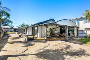 a house with a glass extension on a street at Arkhos - Whitianga Holiday Home in Whitianga