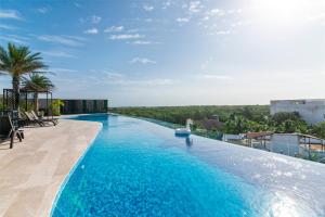 una piscina en la azotea de un edificio en Vibra Bonito - Boho Chic Studio with Rooftop & Infinite Pool, en Tulum