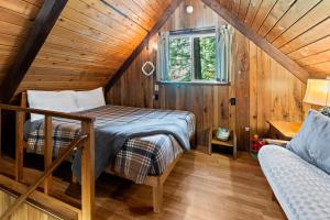 a bedroom with a bed in a wooden cabin at Rainier Vintage Retreat With Hot Tub-Fireplace-WiFi in Ashford
