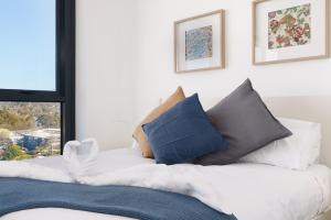ein Schlafzimmer mit einem Bett mit Kissen und einem Fenster in der Unterkunft Bright 1BR Apartment with Stunning Views - Hosted by Canstay in Turner