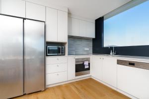 eine Küche mit weißen Schränken und einem Edelstahlkühlschrank in der Unterkunft Bright 1BR Apartment with Stunning Views - Hosted by Canstay in Turner
