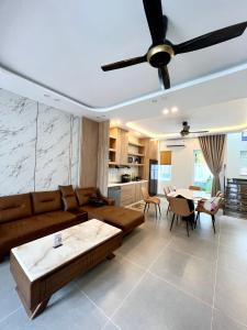 a living room with a couch and a ceiling fan at Villa ATH Novaworld Phan Thiết 3PN in Bình Tú