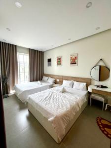a hotel room with two beds and a mirror at Villa ATH Novaworld Phan Thiết 3PN in Bình Tú +23 photos