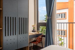 una camera da letto con una scrivania e una finestra di Lantana House Boutique Da Nang a Da Nang
