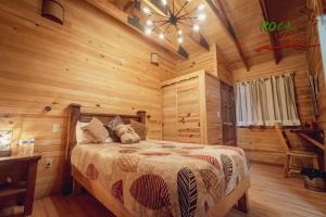 a bedroom with a bed in a log cabin at Roca Venados in Mascota