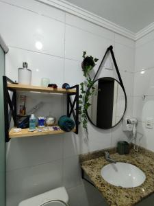 ein Badezimmer mit Waschbecken und Spiegel in der Unterkunft Rosario Apartamento in Santa Maria