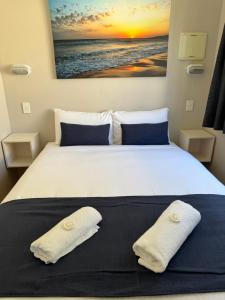 una camera da letto con un letto con due cuscini sopra di Clarence Head Caravan Park a Iluka