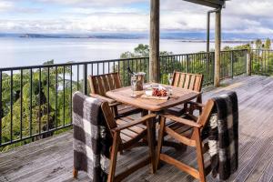 een tafel en stoelen op een terras met uitzicht op het water bij Oreti Collection - By Vacations in Paradise in Turangi