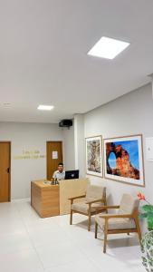 a man sitting at a desk in a waiting room at Pousada Capivara Express in Baixas