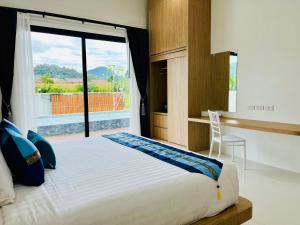 une chambre avec un grand lit et une fenêtre dans l'établissement Unchan Liveliness Pool Villa, à Ban Chong Phli 35 autres photos
