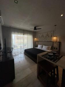 a bedroom with a bed and a table in a room at Studio with balcony in the downtown, WiFi 150MB, laundry and parking free in Tulum