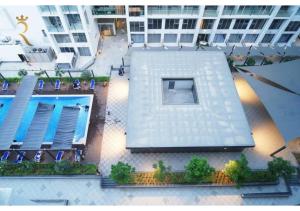 an overhead view of a building with a swimming pool at Jade Serenity 2BR - Pool, Gym & Comfort Near Masdar Park, Masdar City in Abu Dhabi