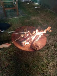 een grill met een vuur in het gras bij Refugio 4 suites com ar condicionado e piscina in Águas de Santa Barbara +37 foto's