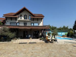 a large house with a swimming pool in front of it at Casa di Nobilis in Gheboieni