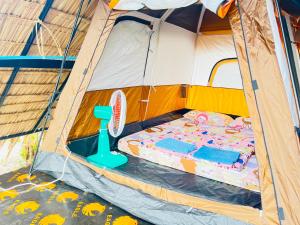 a tent with a bed and a tennis racket in it at Veha Koh Rong in Kaôh Rŭng