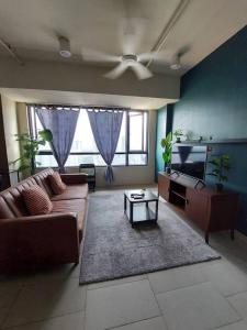 a living room with a couch and a flat screen tv at Kory Homes Relax in Cyberjaya