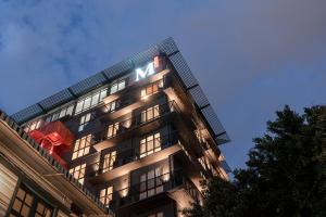 un edificio alto con un letrero de M en M Village Hotel Hai Bà Trưng, en Ho Chi Minh