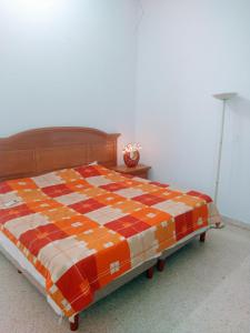 a bedroom with a bed with an orange and white blanket at Casa con aire acondicionado en habitación in Tuxtla Gutiérrez