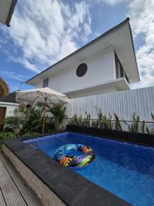a swimming pool in front of a house with an umbrella at Paradise in Lembongan awaits in Nusa Lembongan