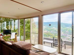 a living room with a couch and a table at Private Fireworks View & Hot spring Villa Atami in Atami
