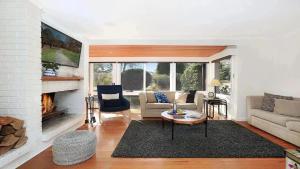a living room with a couch and a fireplace at Cooinda in Kangaloon