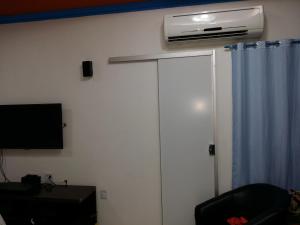 ein Wohnzimmer mit einem TV und einer Wandheizung in der Unterkunft Residencial Adam Lima in Belém