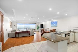an open kitchen and living room with a view of the ocean at Rhyll Seaside Penthouse in Rhyll