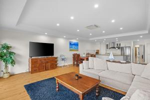 a living room with a couch and a table at Rhyll Seaside Penthouse in Rhyll
