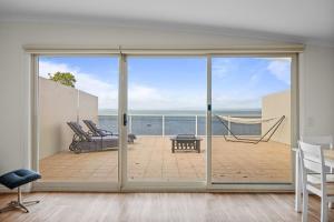 a room with a sliding glass door with a view of the ocean at Rhyll Seaside Penthouse in Rhyll
