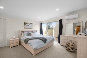 a bedroom with a bed and a sink and a mirror at Rhyll Seaside Penthouse in Rhyll