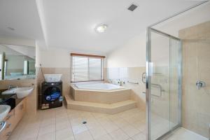 a bathroom with a tub and a shower and a sink at Rhyll Seaside Penthouse in Rhyll +22 photos