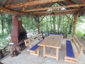 a picnic table and a wood stove in a pavilion at Guesthouse Abrlic in Seliste Dreznicko