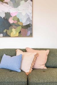 a painting above a couch with pillows on it at Stylish Spacious Apartment in Malvern in Melbourne