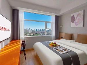a hotel room with two beds and a large window at Shell Hotel Zaozhuang Xinchang Road Bada Market in Zaozhuang +141 photos