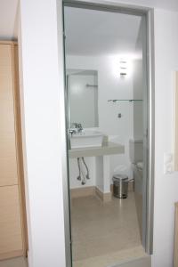 W łazience znajduje się umywalka i lustro. w obiekcie SunOrama Apts-Studios w mieście Balíon