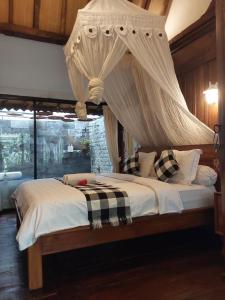 a bedroom with a bed with a canopy at Buratwangi Joglo House in Kerobokan