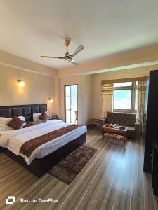 a bedroom with a large bed and a couch at Hotel Shanti Palace in Gangtok
