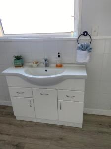 a bathroom with a white sink and a window at Sunny flat 5 minute walk to town in Motueka
