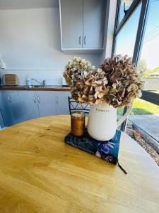 a vase sitting on top of a table with a candle at Sunny flat 5 minute walk to town in Motueka +16 photos