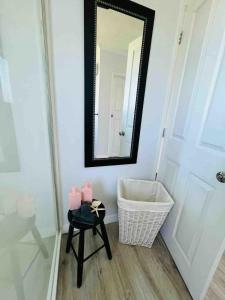 a bathroom with a mirror and a table with pink candles at Sunny flat 5 minute walk to town in Motueka