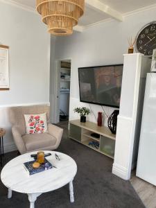 a living room with a coffee table and a tv at Sunny flat 5 minute walk to town in Motueka