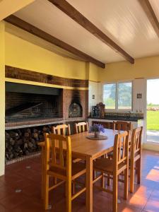 une salle à manger avec une table et des chaises en bois dans l'établissement Los Álamos - casa de campo, à Juan L. Lacaze
