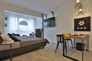 a bedroom with a bed and a table and a dining room at Apartament Zbożowy Rynek 2 in Bydgoszcz
