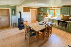a kitchen with a wooden table and a wood stove at Traditional Mountain Farm With Views Of Skogshorn in Hemsedal +17 photos