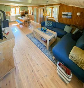a living room with a blue couch and a table at Traditional Mountain Farm With Views Of Skogshorn in Hemsedal