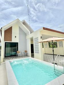 a swimming pool in front of a house at MBP Pool villa เอ็มบีพี พูลวิลล่ายะลา in Changwat Yala