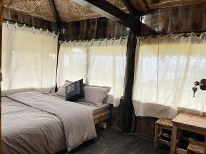 a bed in a room with white curtains at Sapa Local Guide Homestay Trek 2 Days 1 Night or Multi-Day Trekking in Lao Cai