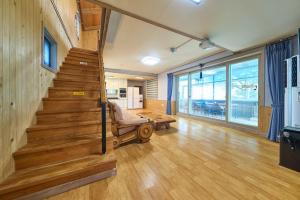 a living room with wooden stairs and a couch at Daebudo Batddureong in Ansan