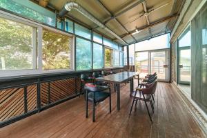 a dining room with a table and chairs and windows at Daebudo Batddureong in Ansan